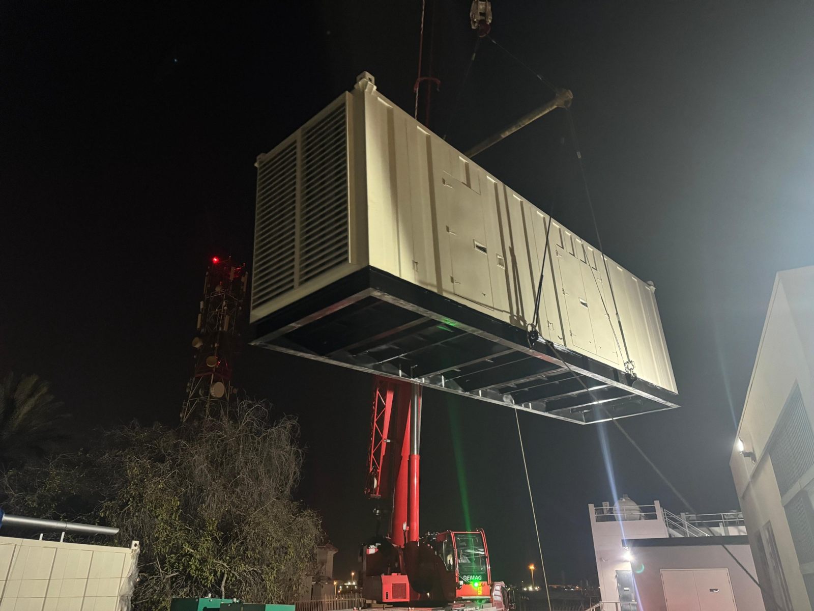 Generator enclosure being lifted by crane on site
